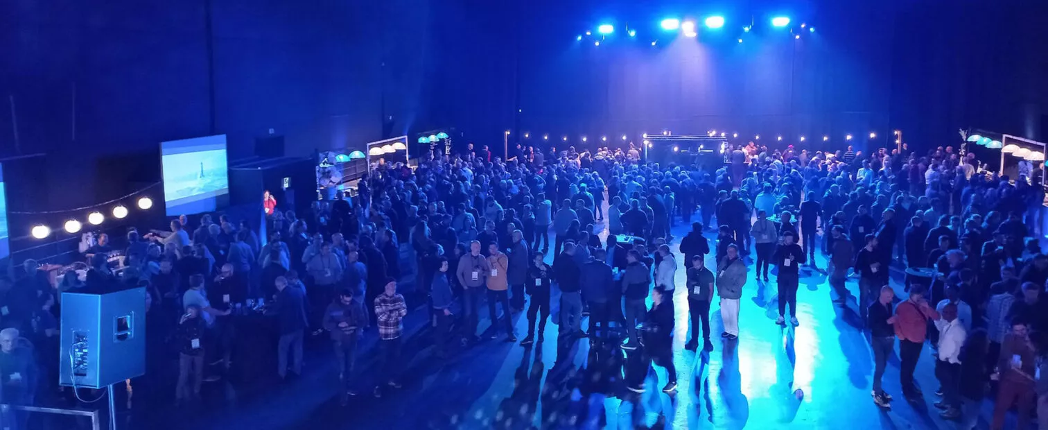 Foule de gens dans un décor bleu dans la salle du Liberté