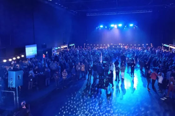 Foule de gens dans un décor bleu dans la salle du Liberté